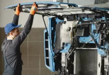 Kiedy warto wymienić kabinę w pojeździe użytkowym Mechanik unosi odchyloną kabinę ciężarówki podczas przeglądu