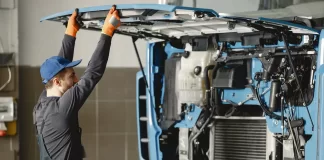 Mechanik unosi odchyloną kabinę ciężarówki podczas przeglądu