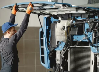 Kiedy warto wymienić kabinę w pojeździe użytkowym Mechanik unosi odchyloną kabinę ciężarówki podczas przeglądu
