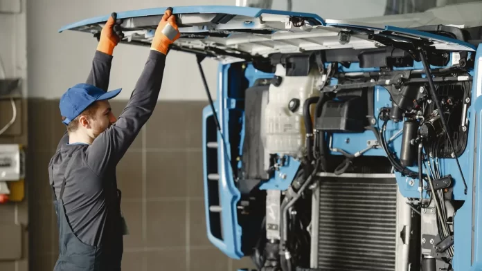 Mechanik unosi odchyloną kabinę ciężarówki podczas przeglądu